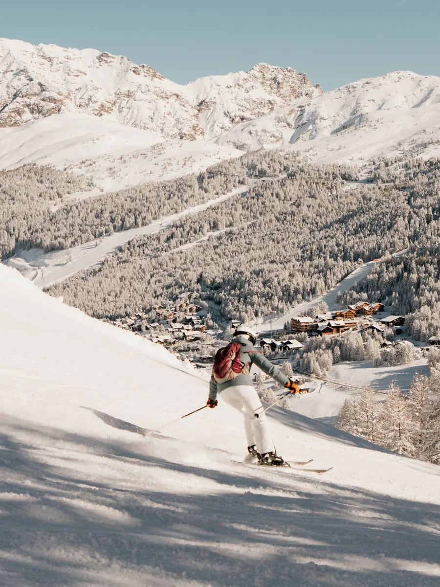 Sciatrice in discesa con vista su Livigno